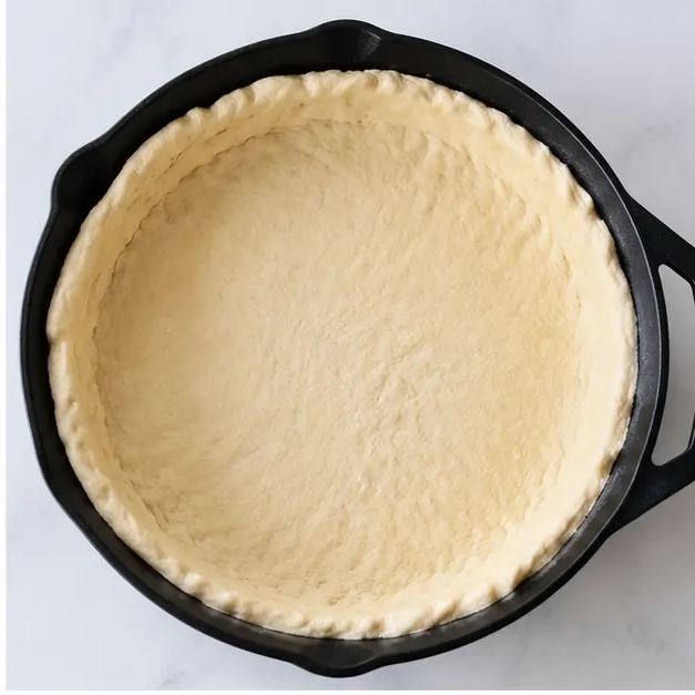Step 2: Pressing dough into a cast iron skillet