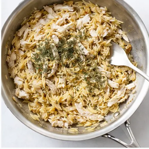Step 2: Stirring in orzo pasta and shredded chicken fillet