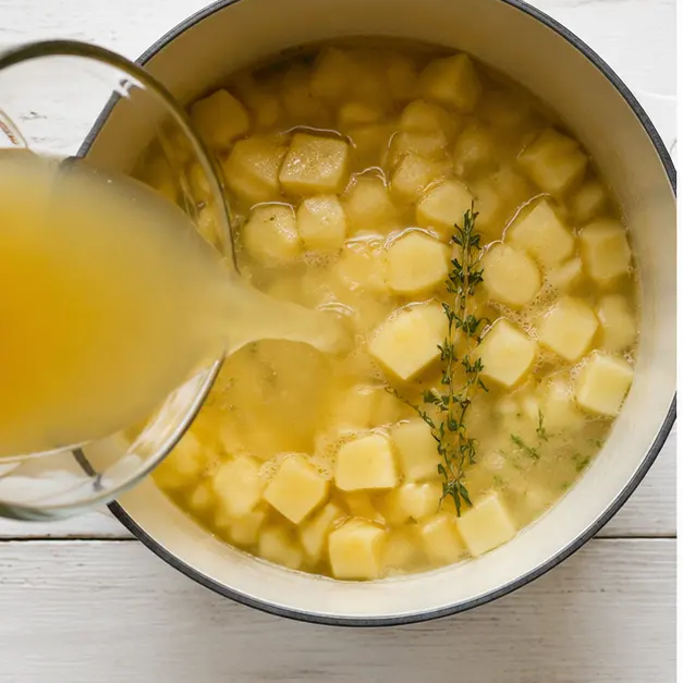 Step 3: Adding broth, potatoes, and thyme
