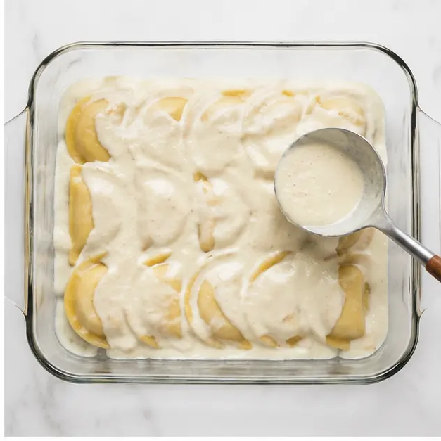 Step 2: Spoon Alfredo sauce evenly over the pierogies