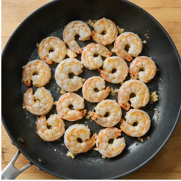 Step 2: Searing shrimp in a hot skillet until opaque and golden.
