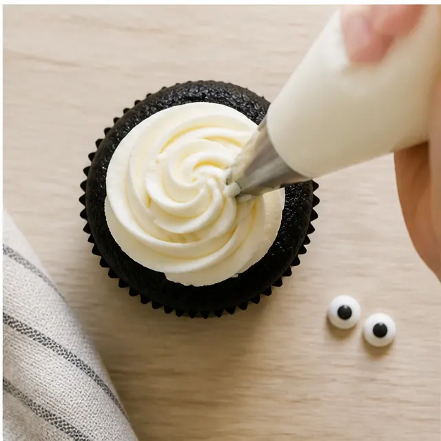 Pipe the white ghost frosting and add eyes