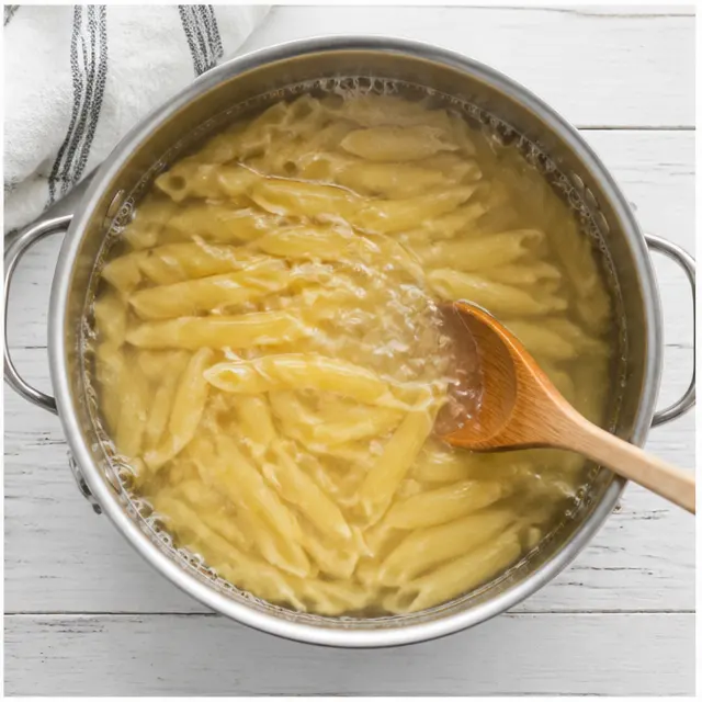 Cooking penne pasta in boiling salted water until al dente