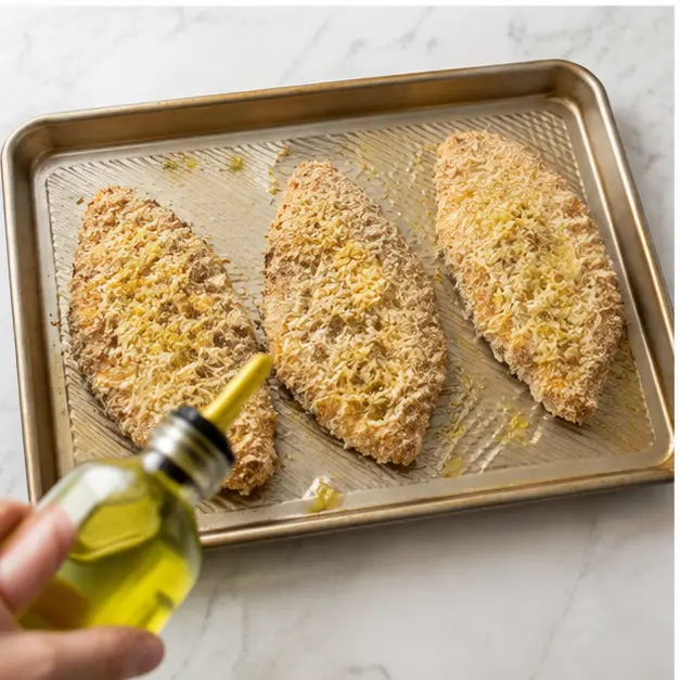 Step 3: Arranging breaded cutlets on baking sheet with oil drizzle