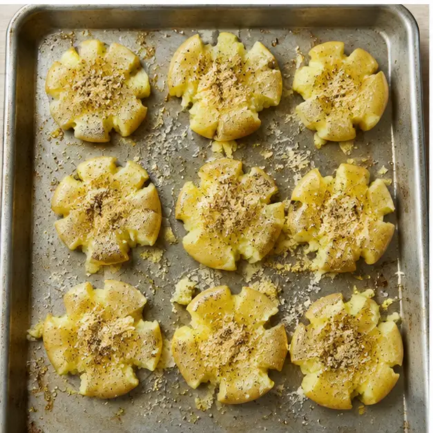 Step 3: Drizzling olive oil and sprinkling seasonings over smashed potatoes