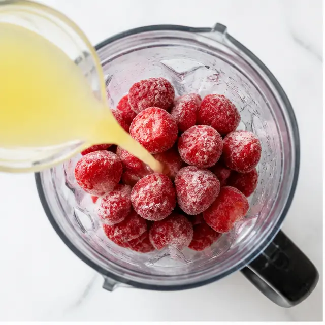 Combine frozen strawberries with lemon juice and sugar in blender jar