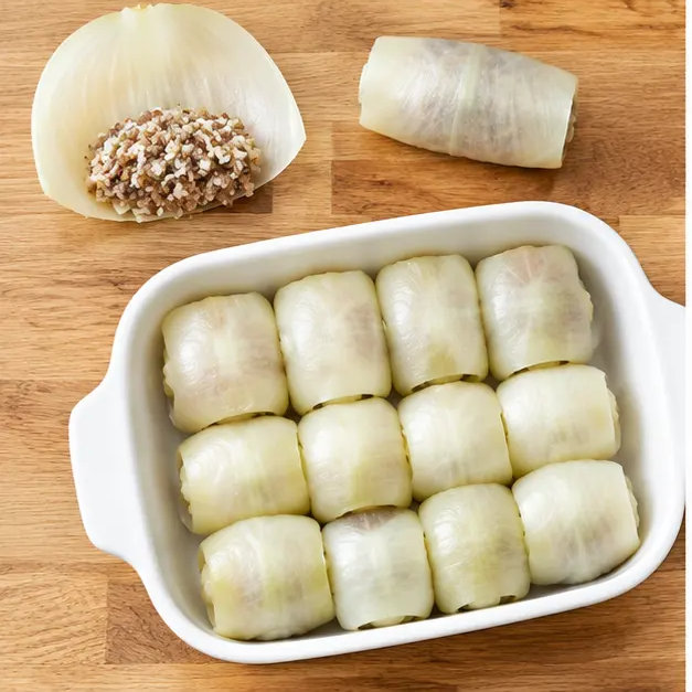 Step 3: Rolling soft onion leaves around the filling and arranging them in a baking dish
