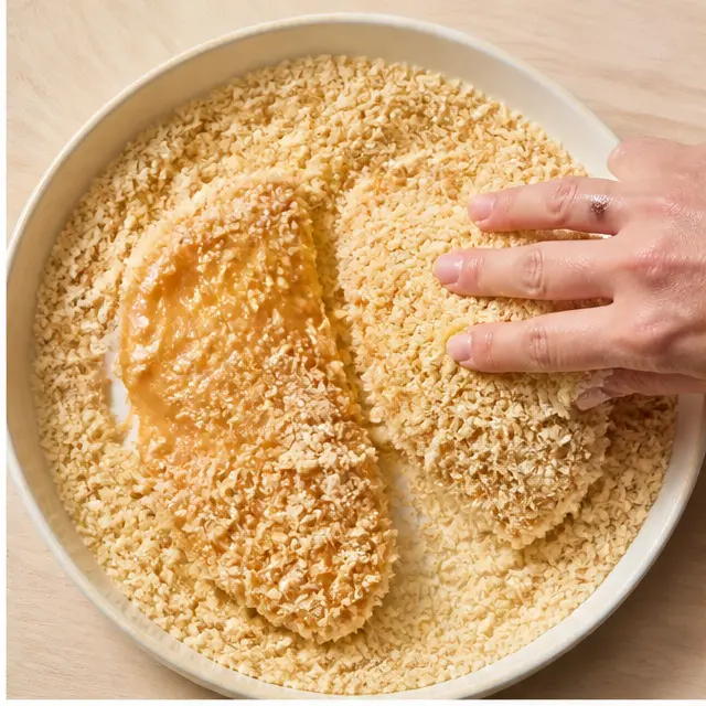 Step 2: Pressing egg-washed fillets into panko breadcrumbs