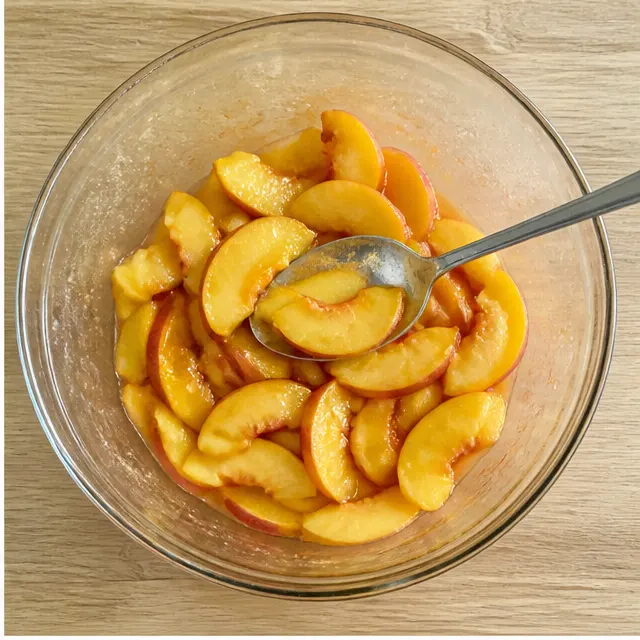Step 2: Tossing ripe peach slices with lemon juice, sugar, and cornstarch