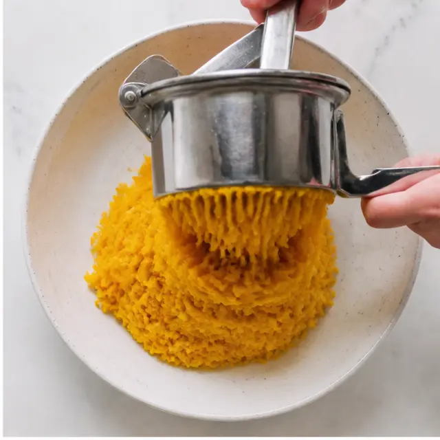 Step 2: Mashing vegetables through ricer