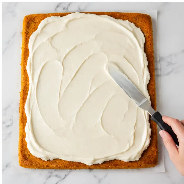 Spread the cream cheese filling over the unrolled cooled cake