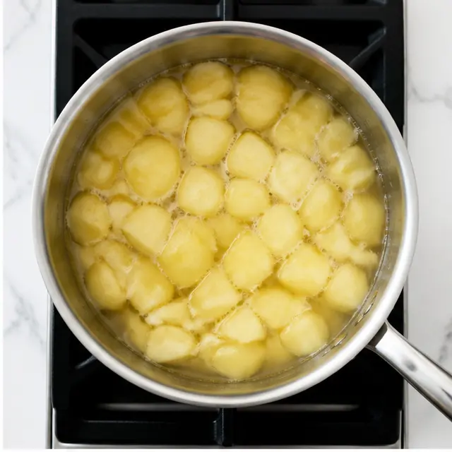 Step 2: Simmering apple chunks with water and lemon juice in a covered saucepan.