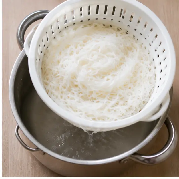 Drain cooked rice vermicelli noodles in a colander